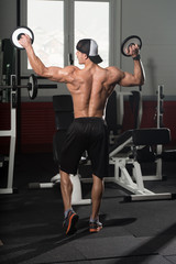 Fototapeta na wymiar Bodybuilder Posing Biceps After Exercises With Weights