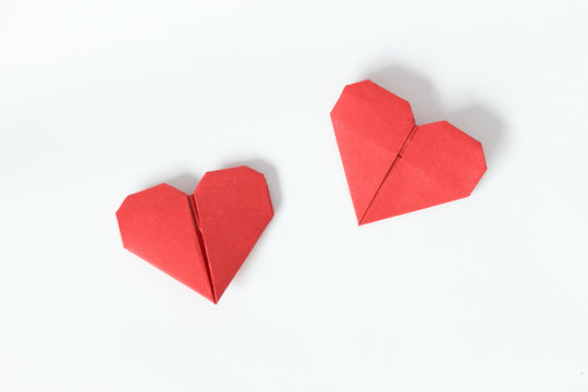 Two red origami hearts on white background. Valentin's Day gift cards. Top view.
