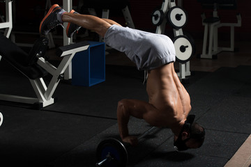 Man Exercising Push-Ups On Barbell In Elevation Mask