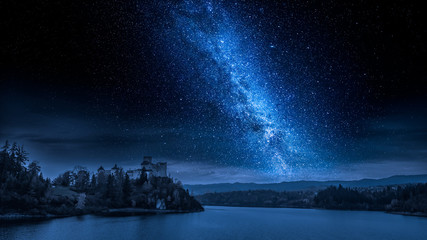 Beau château au bord du lac la nuit avec voie lactée