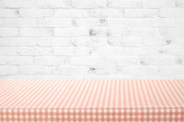 Empty table cover with pink and white tablecloth over white brick wall background, banner, table top, counter design for food and product display montage