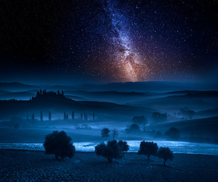 Milky way over fields in the valley in Tuscany, Italy