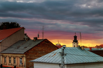 Sunset evening sky pink clouds of the roof of the houses of Uzhhorod city, Ukraine