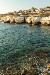 Sea caves formed by water at the coast of Cyprys - obrazy, fototapety, plakaty