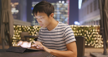 Man use of digital tablet computer at night