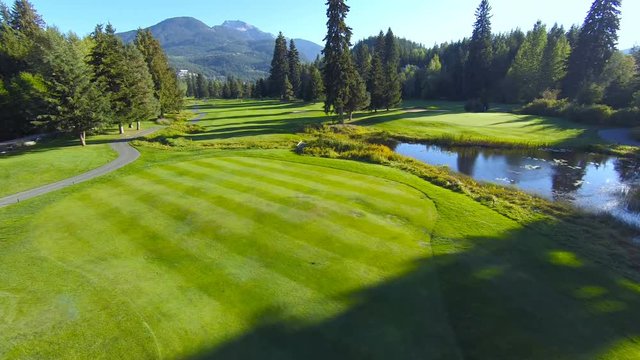 4K aerial footage of golf course in the mountains, sun setting