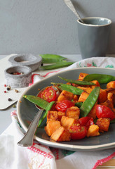 Süsskartoffelpfanne mit Zuckerschoten und Strauchtomaten