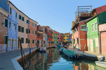 Fototapeta na wymiar A sunny day on the city canal of the colorful Burano Island. Venice