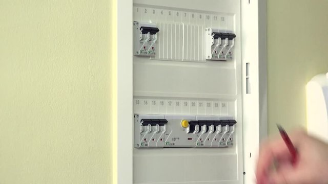 Hand of an electrician turning on a fuses. Closeup