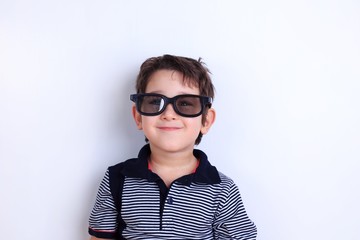 Happy lovely smiling boy in sunglasses, studio shoot on white. Children, fashion and lifestyle concept