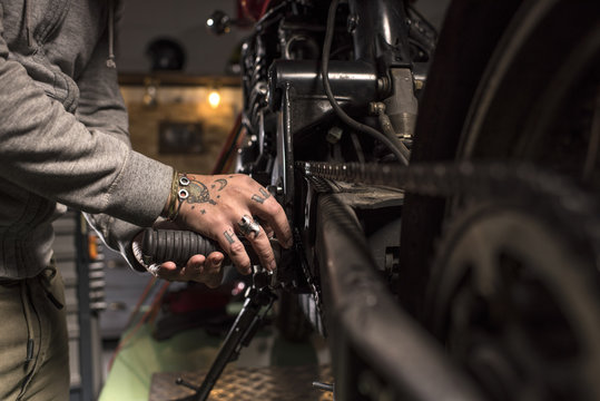 Close-up of mechanic fixing a motorbike