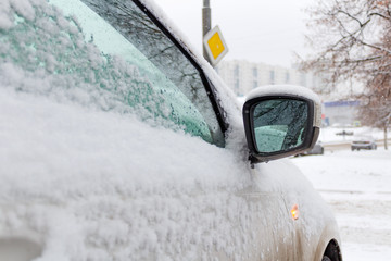 Snow covered side mirror of the car. Side view