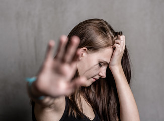 teenage girl showing a stop sign, wanting to be left alone