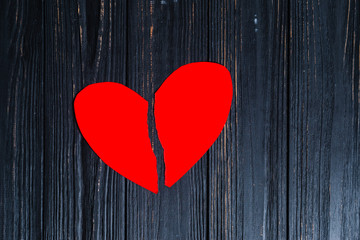 torn red heart on paper, on a dark background
