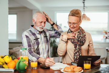 Senior couple counting bills at home