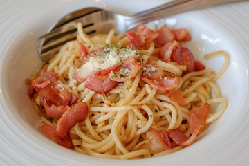 Spaghetti with bacon in white plate