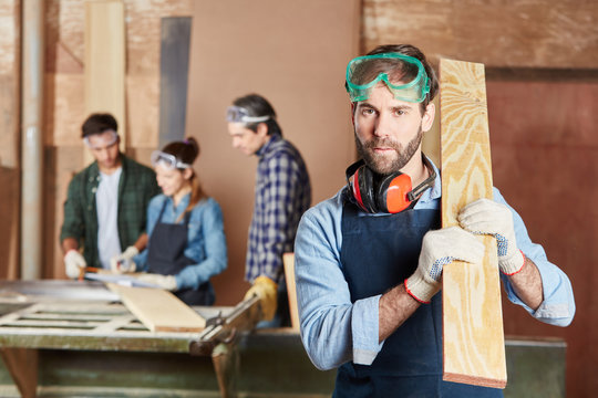 Schreiner mit Holzbrett in Werkstatt