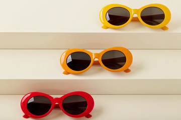 Sunglasses of red, orange and yellow colors on a white background.