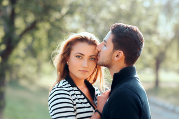 Fototapeta premium Protective Loving Man Kissing Girlfriend on The Forehead