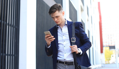Fototapeta premium Young urban businessman professional on smartphone walking in street using mobile phone.