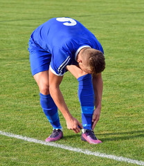 Obraz premium Soccer player wraps his shoes