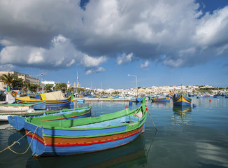 Naklejka na ściany i meble maltese traditional painted luzzu boats in marsaxlokk fishing village malta