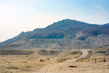  Entrances of tombs excavated in rock belonging to personalities of the Egyptian empire in a very arid mountain without vegetation seen from the forecourt of the temple of Hatshepsut. Without people