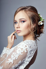 Young bride in a luxurious white wedding dress and beautiful hair. Woman before the wedding ceremony, a perfect figure of the bride, beautiful makeup and hairstyle