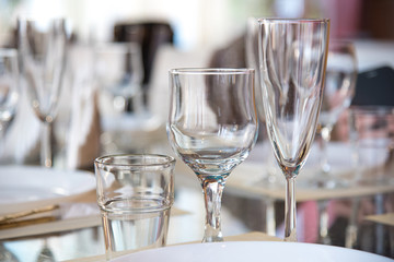 Table setting in the restaurant, including glasses for wine, champagne and cognac, napkins and plates for guests