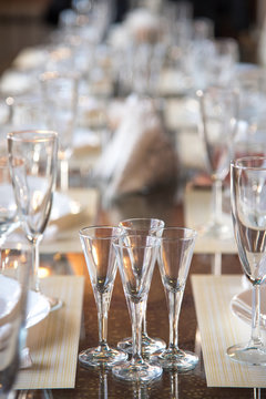 Table setting in the restaurant, including glasses for wine, champagne and cognac, napkins and plates for guests