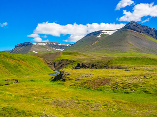 View of mountain, valley and stream in the blue sky