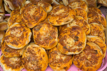 Mini-pizzas heaped on a wooden Board background .