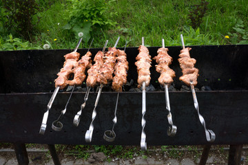 Shish kebab on the grill cooked on a metal skewer. Roasted meat cooked on a barbecue. Skewers of...