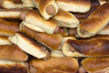 Freshly baked small buns in a ceramic bowl. Sausage in the dough. The top view