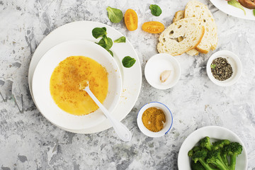 Ingredients for cooking scrambled eggs or omelets with green herbs, fresh vegetables, broccoli and turmeric as a healthy breakfast or lunch option. View from above. Against a light background.