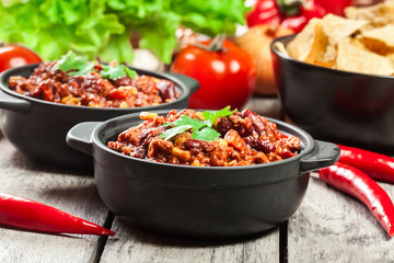 Bowls of hot chili con carne with ground beef, beans, tomatoes and corn