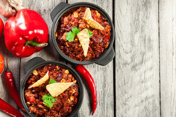 Bowls of hot chili con carne with ground beef, beans, tomatoes a