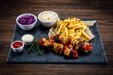 Kebabs - grilled meat with french fries and vegetables on white background