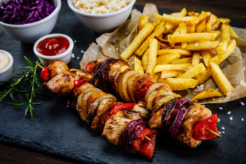 Kebabs - grilled meat with french fries and vegetables on white background