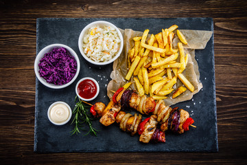 Kebabs - grilled meat with french fries and vegetables on white background