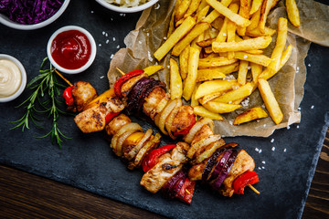 Kebabs - grilled meat with french fries and vegetables on white background