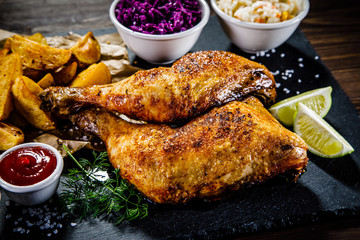 Grilled chicken legs with French fries and vegetables