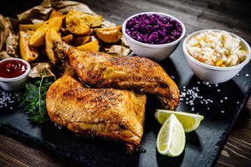 Grilled chicken legs with French fries and vegetables