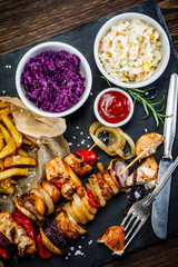 Kebabs - grilled meat with french fries and vegetables on white background