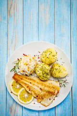 Fish dish - fried fish fillet boiled potatoes and vegetables