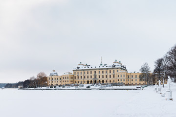 Fototapeta na wymiar View over Drottningholm Palace and lake on a winter day. Home residence of Swedish royal family. Famous landmark and tourist destination in Stockholm, Sweden