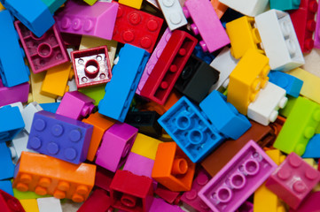 Fototapeta na wymiar Childrens Designer Background. Multicolored plastic building blocks of the designer.