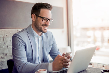 Young businessman working in office, sitting at desk.