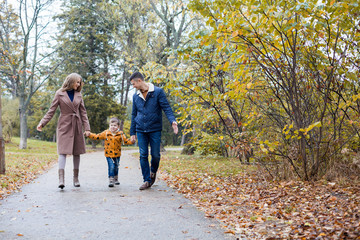 mom dad and a little boy walk in the Park