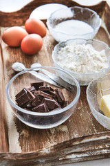 Baking ingredients for chocolate cake muffins or cookies lying ready on wooden kitchen tray. Mise...